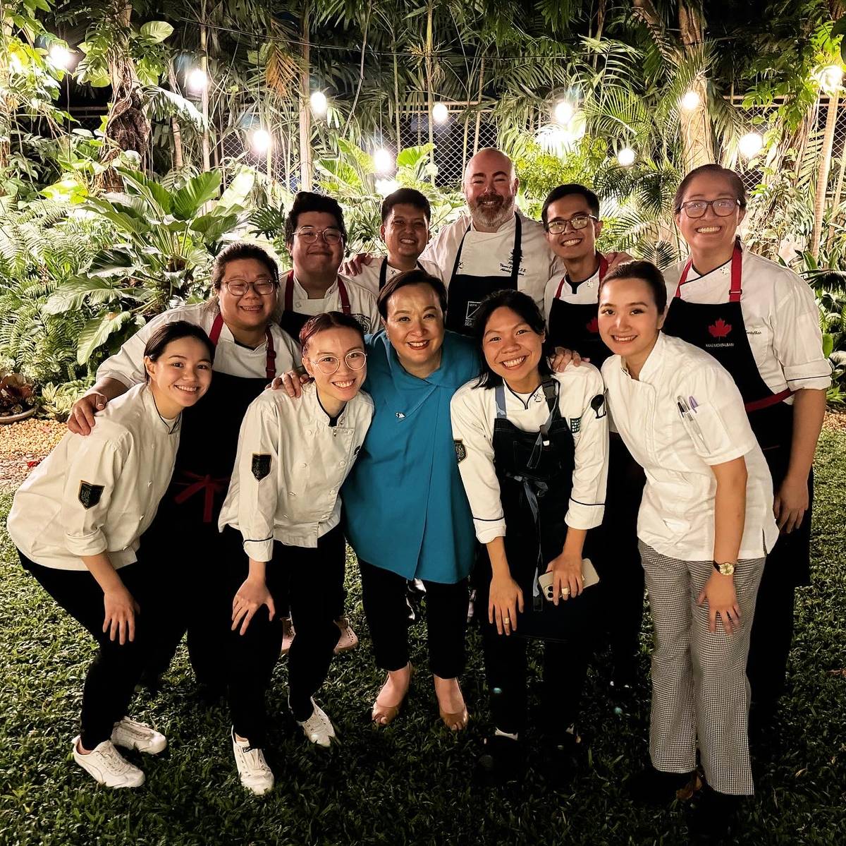 Chef Margarita Marty (center, in blue) and Chef Thomas Carey (back row, center) with Benilde students and alum, February 2024.