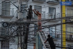 Naked man climbs electric post