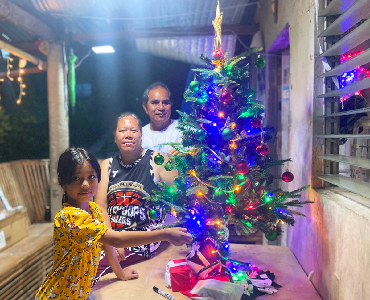 Together with his family, Arnulfo (right) adorns their first Christmas tree with lights, baubles and trimmings.