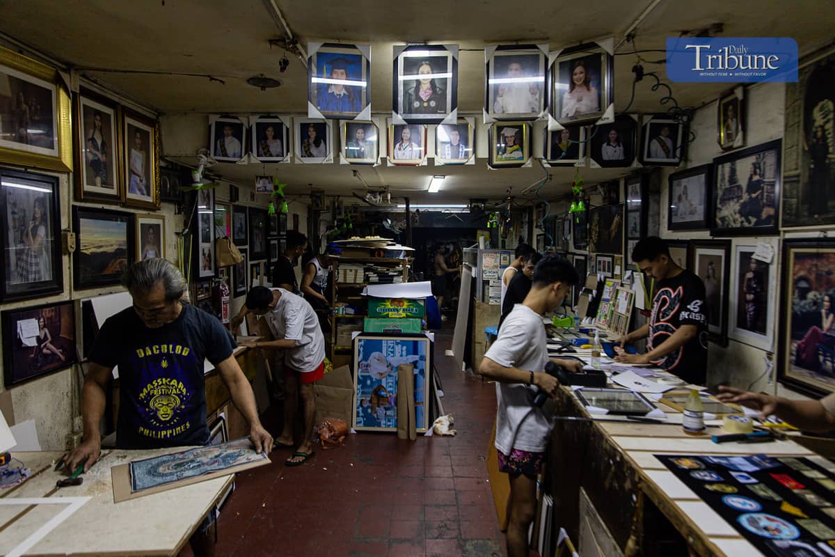 Staff at a Quiapo frame shop work on frames ahead of the holiday rush.