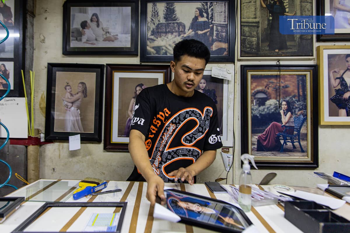 Staff at a Quiapo frame shop work on frames ahead of the holiday rush.