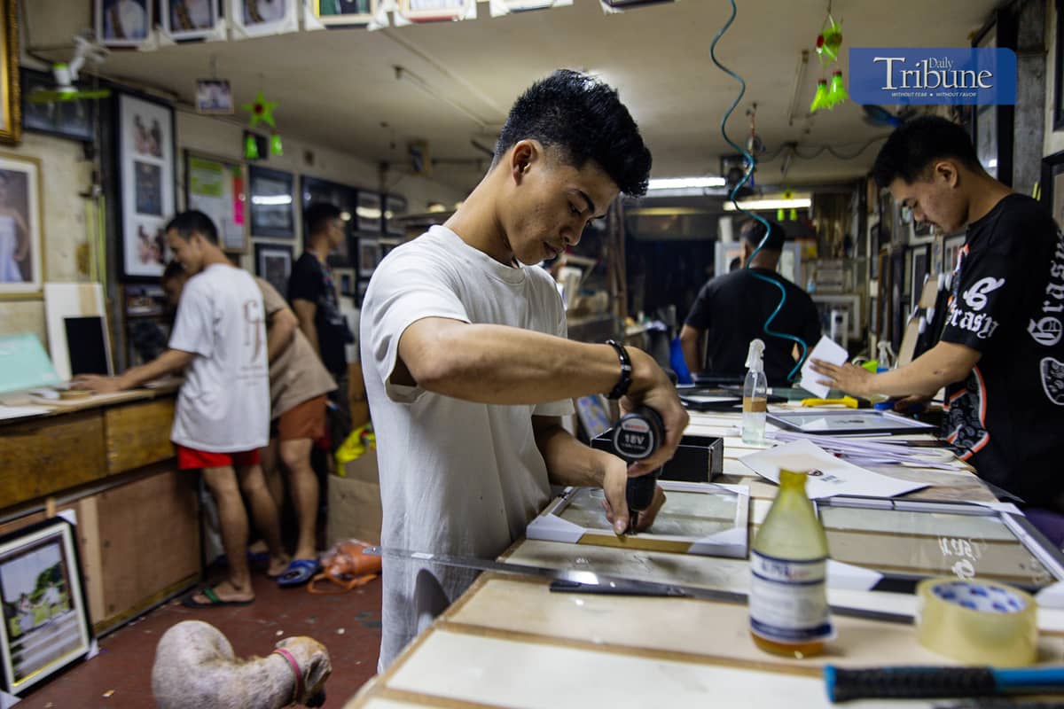 Staff at a Quiapo frame shop work on frames ahead of the holiday rush.