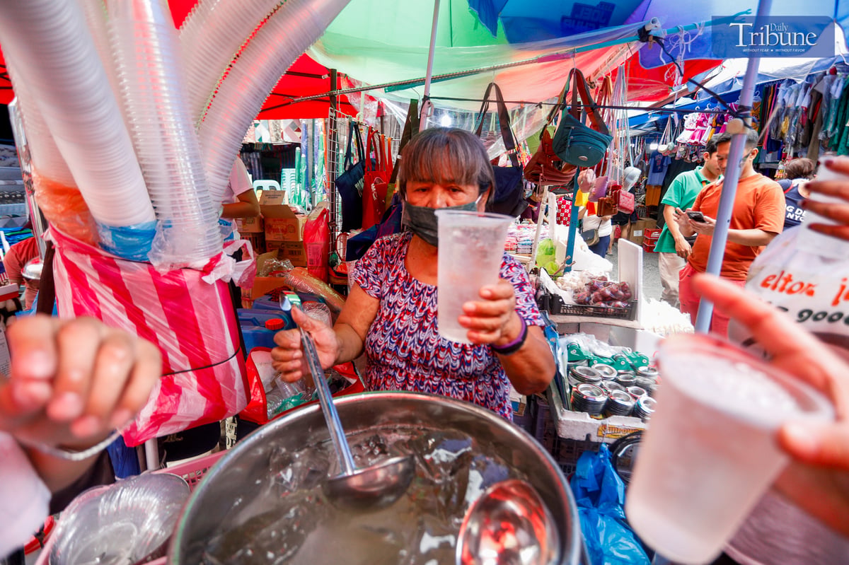 Aling Bebe serves her viral “Magic Water,” a refreshing clear gulaman drink, to quench the thirst of shoppers along Juan Luna Street in Divisoria, Manila.