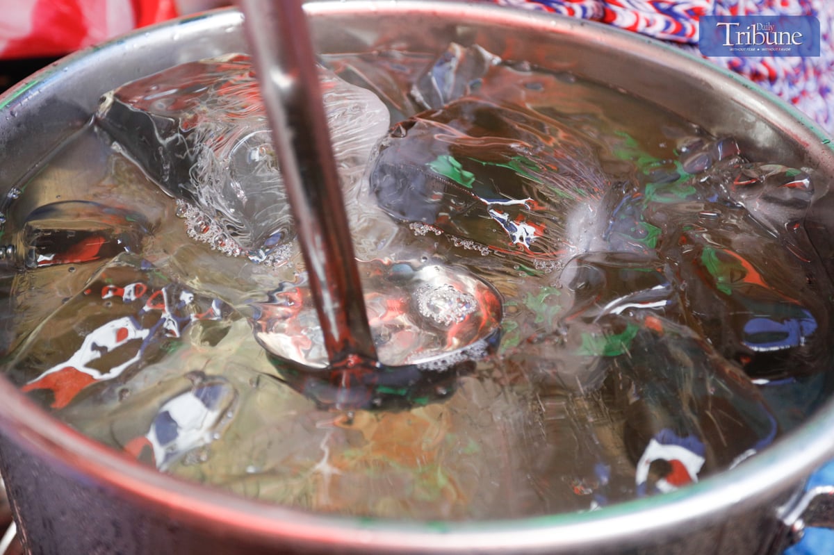 Aling Bebe serves her viral “Magic Water,” a refreshing clear gulaman drink, to quench the thirst of shoppers along Juan Luna Street in Divisoria, Manila.