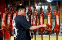 Workers prepare delicious lechon baboy (roasted pig) at various stores in La Loma, Quezon City, on Sunday, 22 December, 2024. Lechon remains a popular choice for Noche Buena, the traditional Christmas Eve feast.