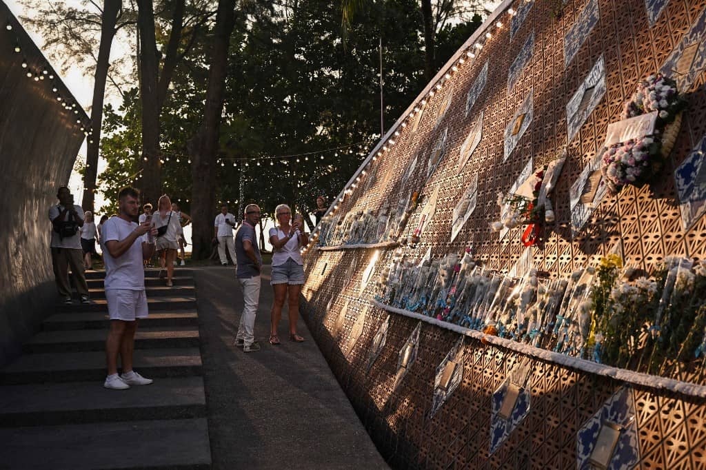 People visit the Ban Nam Khem Tsunami Memorial Park wall in southern Thai province of Phang Nga on 26 December 2024. Emotional ceremonies began across Asia on 26 December to remember the 220,000 people who died two decades ago when a tsunami devastated coastal areas around the Indian Ocean, in one of the worst natural disasters in human history.