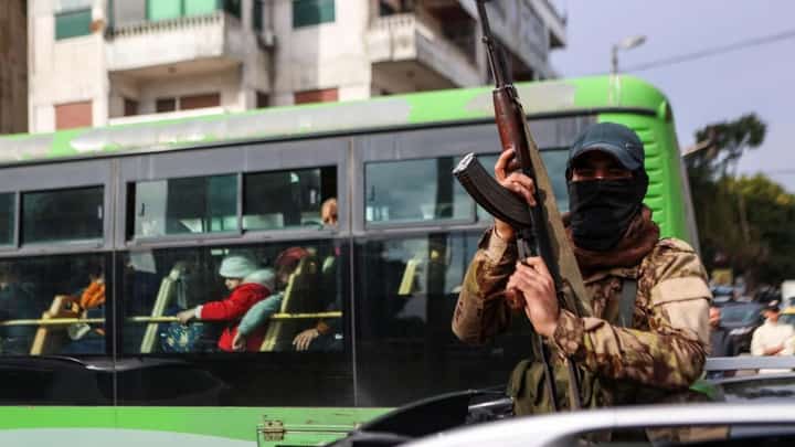 A fighter affiliated with Syria's new administration gestures with his rifle in Syria's western coastal city of Latakia on Dec. 26, 2024.
