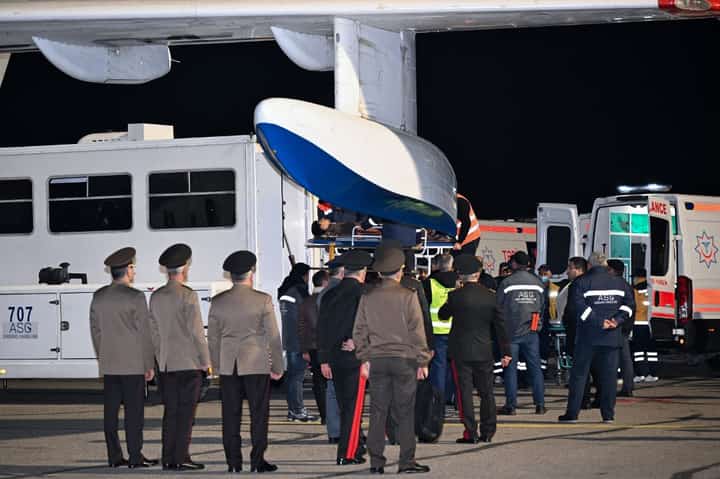 Airport ground staff and medics assist Azerbaijani citizens, who survived the crash of the Azerbaijan Airlines' Embraer 190 passenger jet near the western Kazakh city of Aktau, upon arrival at Baku's Heydar Aliyev International Airport on 26 December, 2024.
