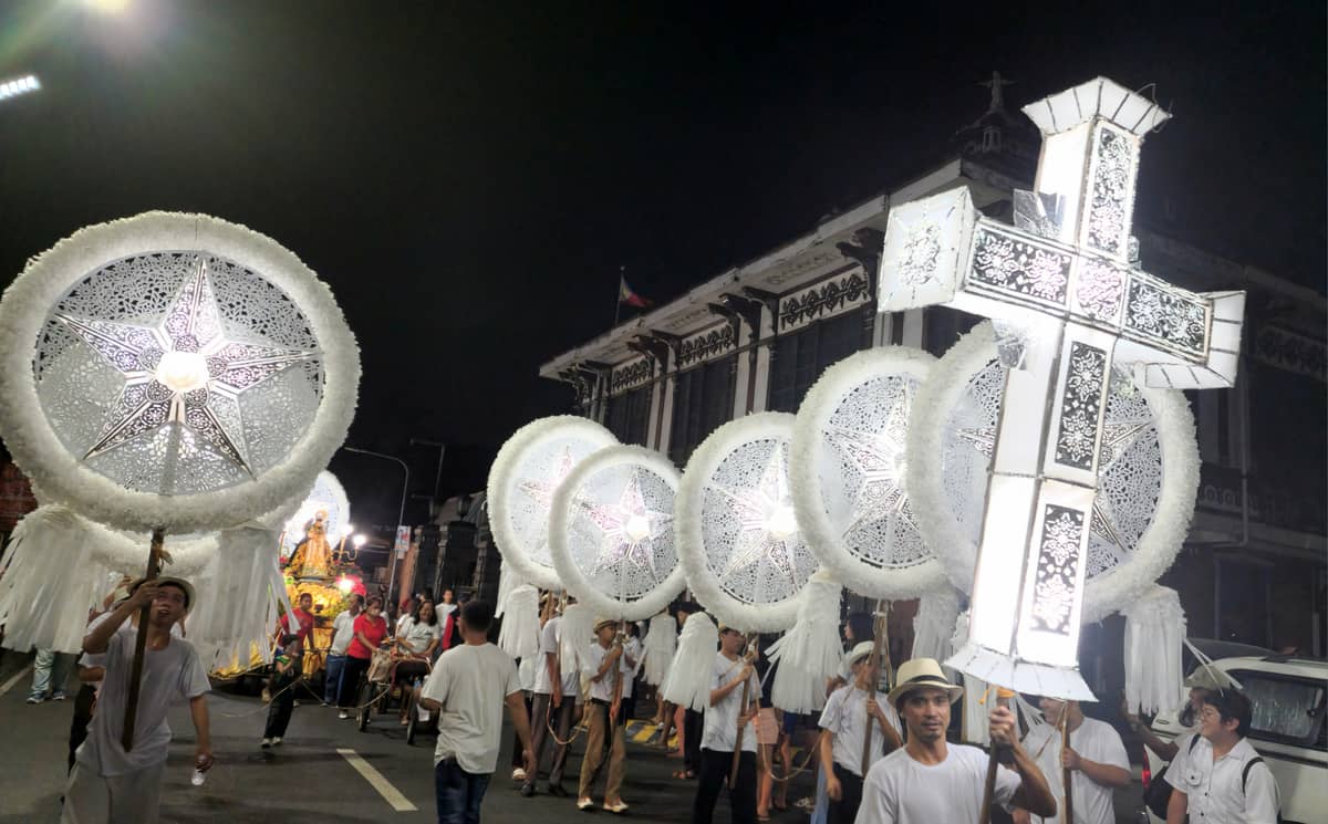 A cross-shaped lantern leads the procession.