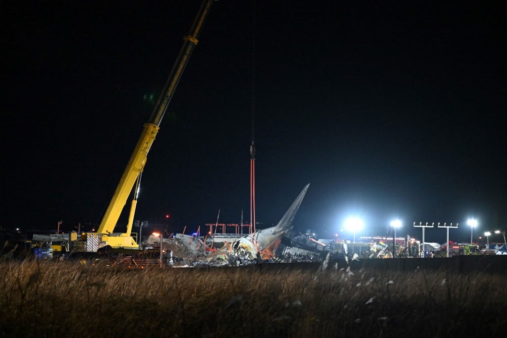 Firefighters and rescue personnel work at the site of a Jeju Air Boeing 737-800 crash at Muan International Airport in South Jeolla Province, 288 kilometers southwest of Seoul, on 29 December 2024. The plane, carrying 181 people from Thailand to South Korea, crashed into a barrier and burst into flames, leaving 179 dead.