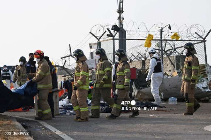 Firefighters and rescue personnel work near the scene where a Jeju Air Boeing 737-800 series aircraft crashed and burst into flames at Muan International Airport in South Jeolla Province, some 288 kilometres southwest of Seoul on December 29, 2024. A Jeju Air plane carrying 181 people from Bangkok to South Korea crashed on arrival December 29, colliding with a barrier and bursting into flames, with only two survivors rescued so far and 120 confirmed dead.