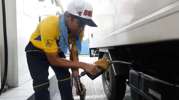 A gasoline attendant fills the tank of a truck in Quezon City on Monday, as petroleum products starting Tuesday, 31 December are scheduled to go down.