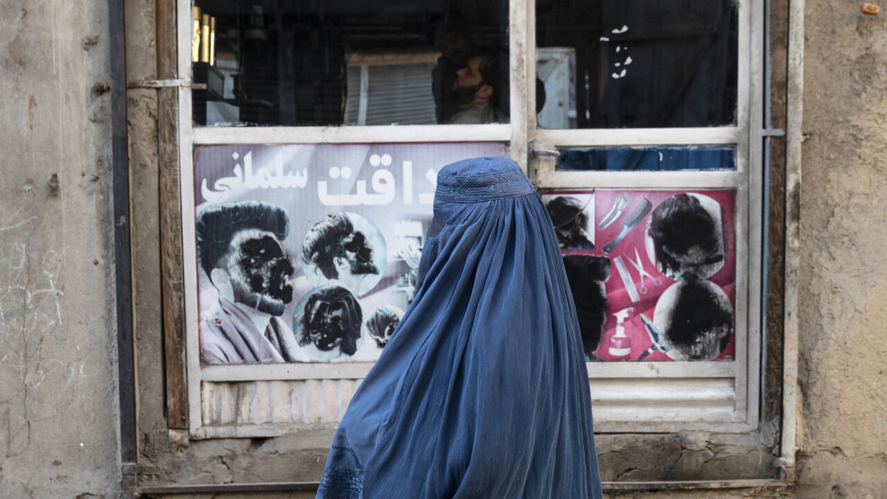 An Afghan woman stands by a window in Kabul on January 31, 2024.