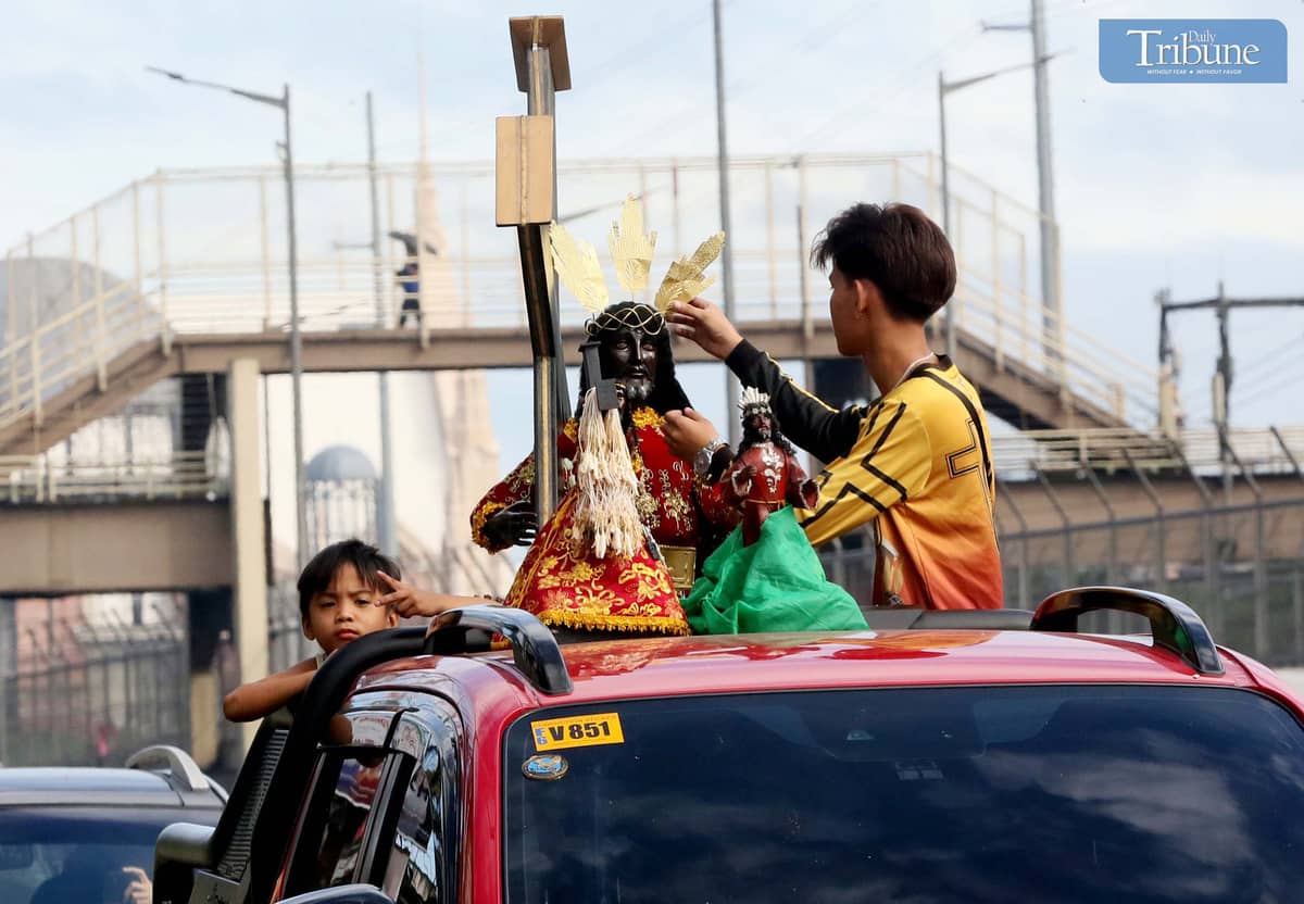 On Thursday, 2 January, a devotee wipes a replica of the Black Nazarene aboard a vehicle en route to Quiapo Church for a blessing ahead of the 9 January feast.