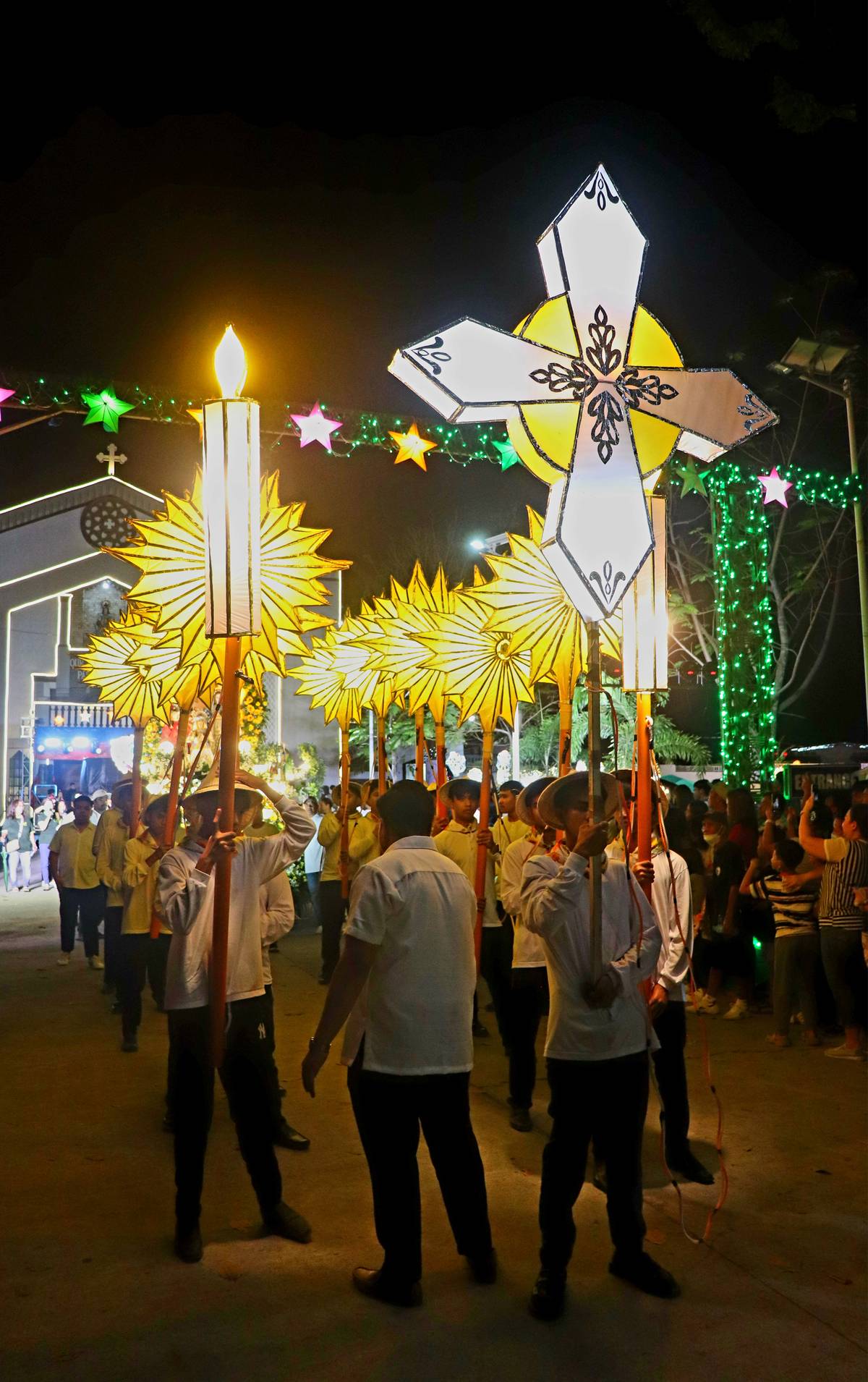 A cross-shaped lantern leads the maitinis procession.