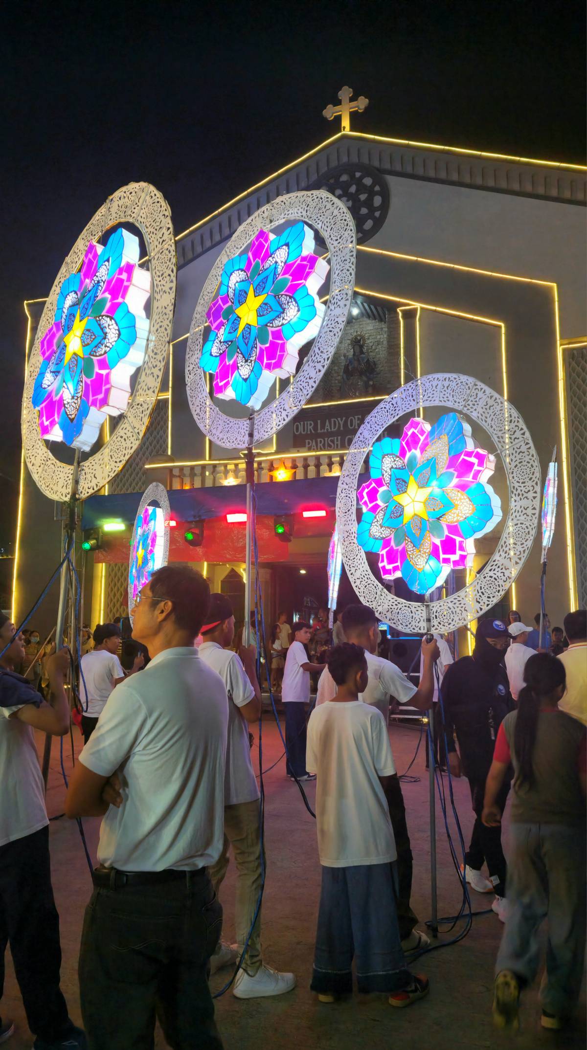 Devotees carry Chrtistmas lanterns to the church for the maitinis procession.