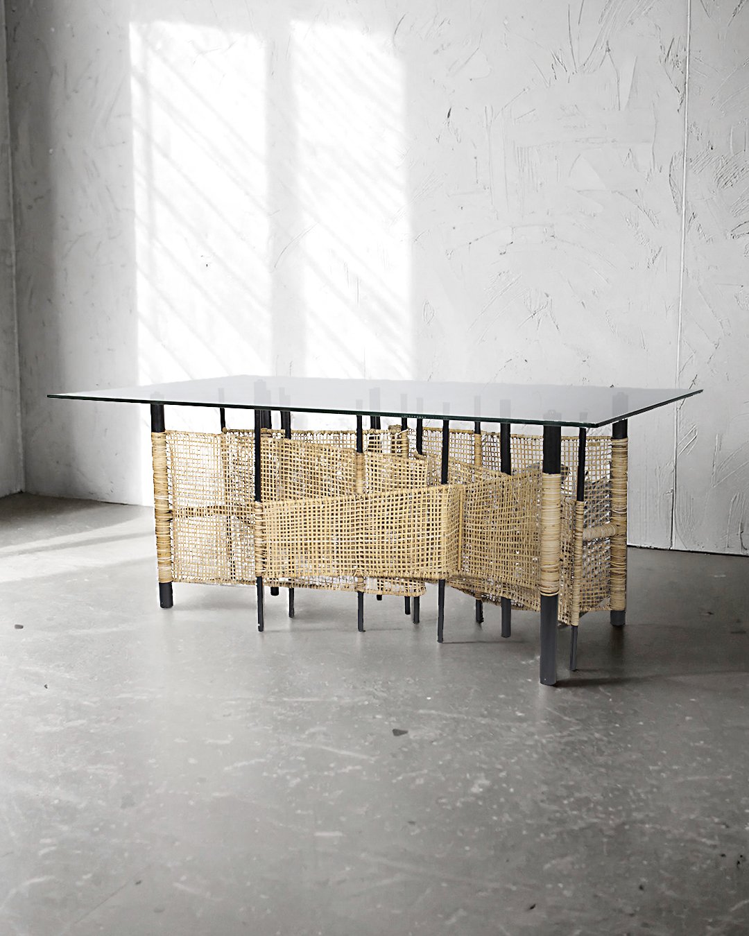 Lambat eight-seater dining table. Rooted in modernity, this Lambat eight-seater dining table seamlessly blends rustic charm with contemporary elegance. Its sturdy beige rattan frame evokes natural, earthy textures, while the sleek glass top adds a touch of sophistication, making it the perfect centerpiece for a cozy, modern dining space