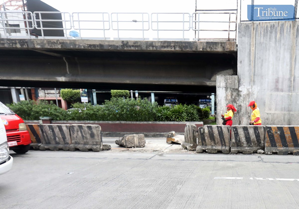 Workers cleaned debris after a pickup truck crashed into two concrete barriers on EDSA in Quezon City on Monday, 13 January 2025.