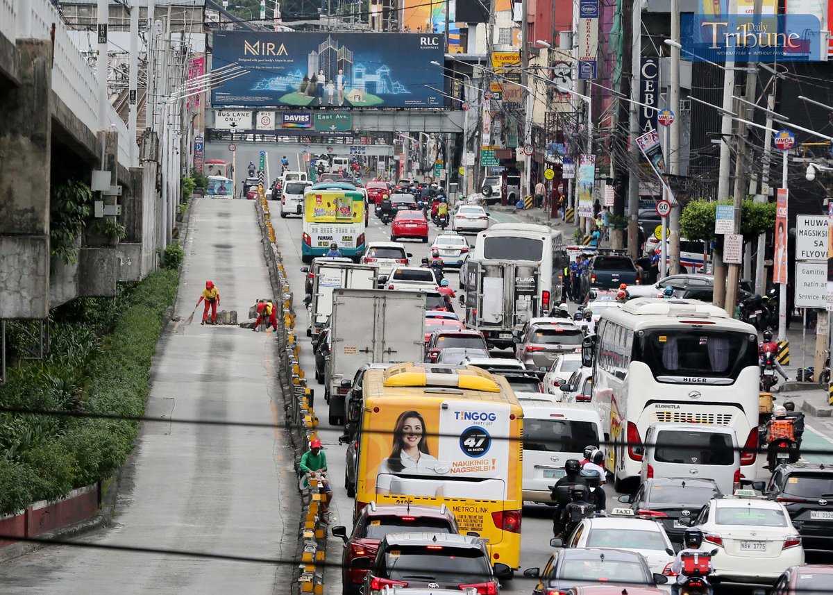 Workers cleaned debris after a pickup truck crashed into two concrete barriers on EDSA in Quezon City on Monday, 13 January 2025.