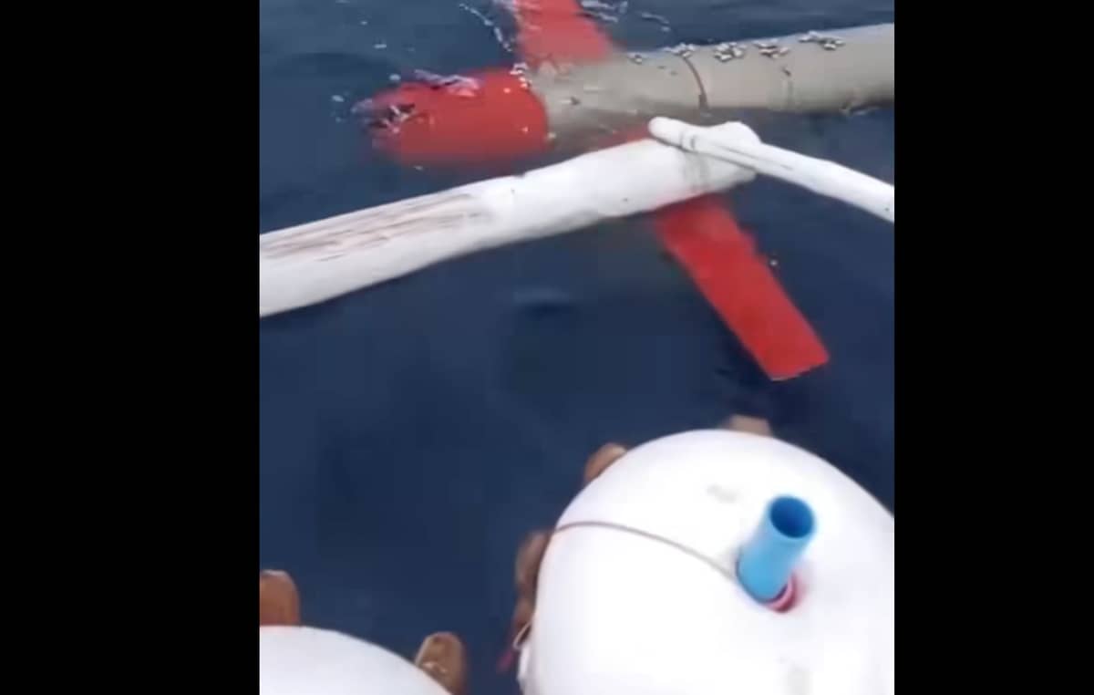 Screenshot of the silver and red drone caught on video drifting near a fishing vessel.
