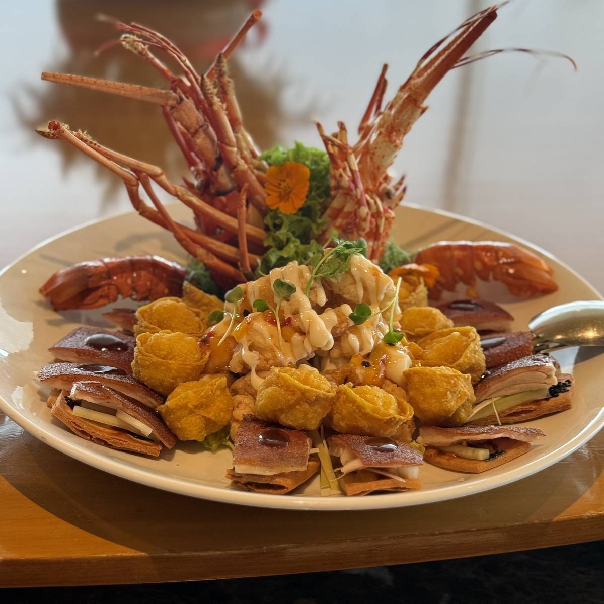 Deep fried lobster salad and gold ingots wonton passion fruit dressing with combination suckling pig.