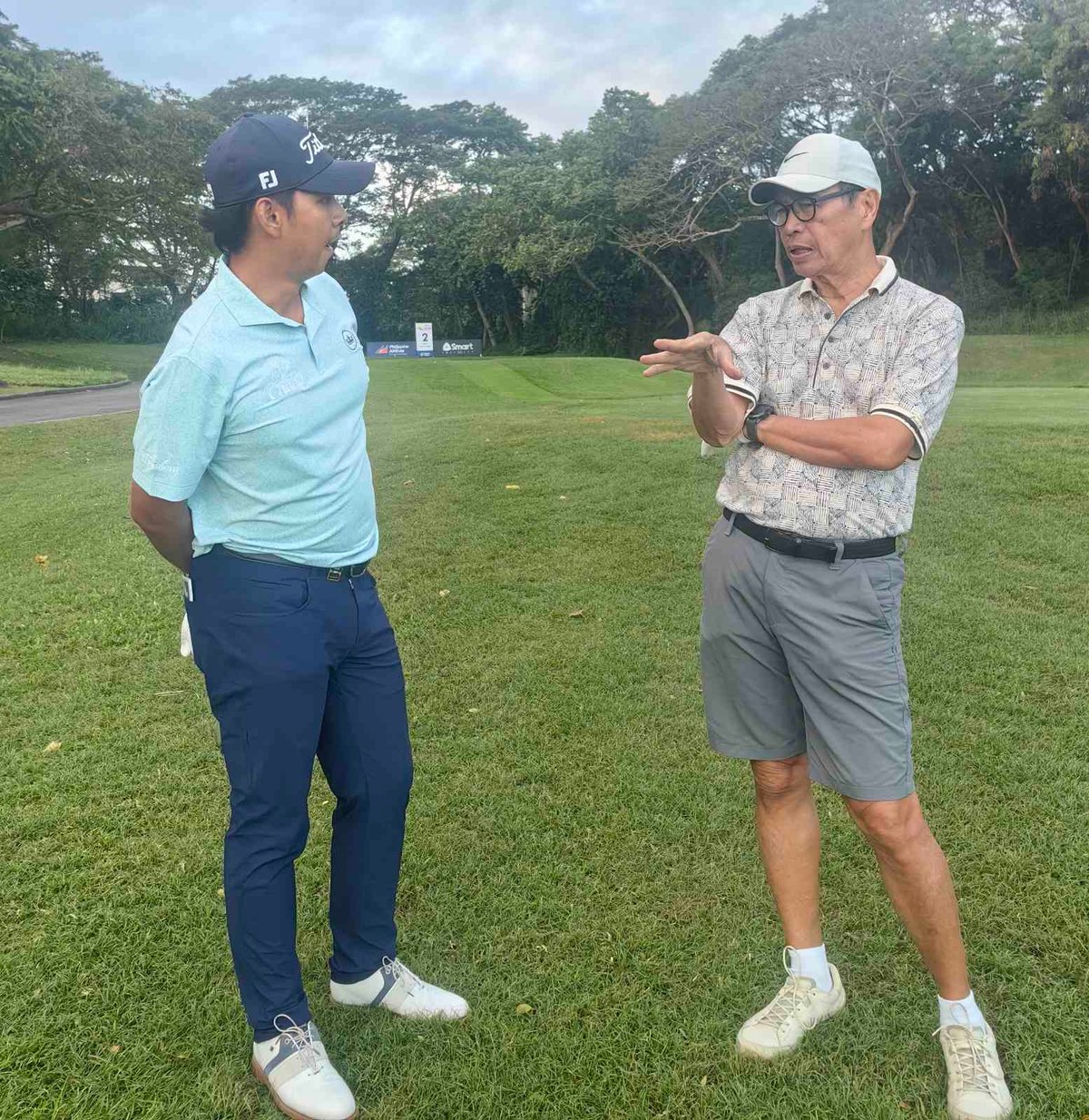 Three-time Asian Tour champion Nittithorn Thippong of Thailand shares a light moment with veteran journalist Jun Engracia before the start of the Philippine Open pro-am tournament at the Masters Course of Manila Southwoods Golf and Country Club in Carmona, Cavite, on Wednesday.