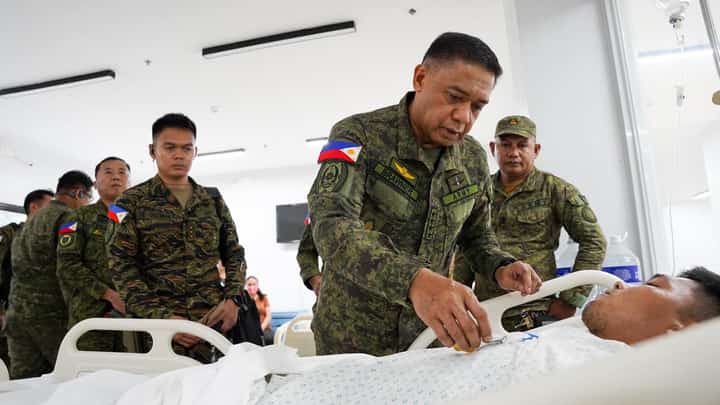 AFP Chief of Staff General Romeo Brawner pins the Wounded Personnel Medal to a soldier of the 32nd Infantry Battalion wounded in an encounter in Basilan Province on Wednesday.