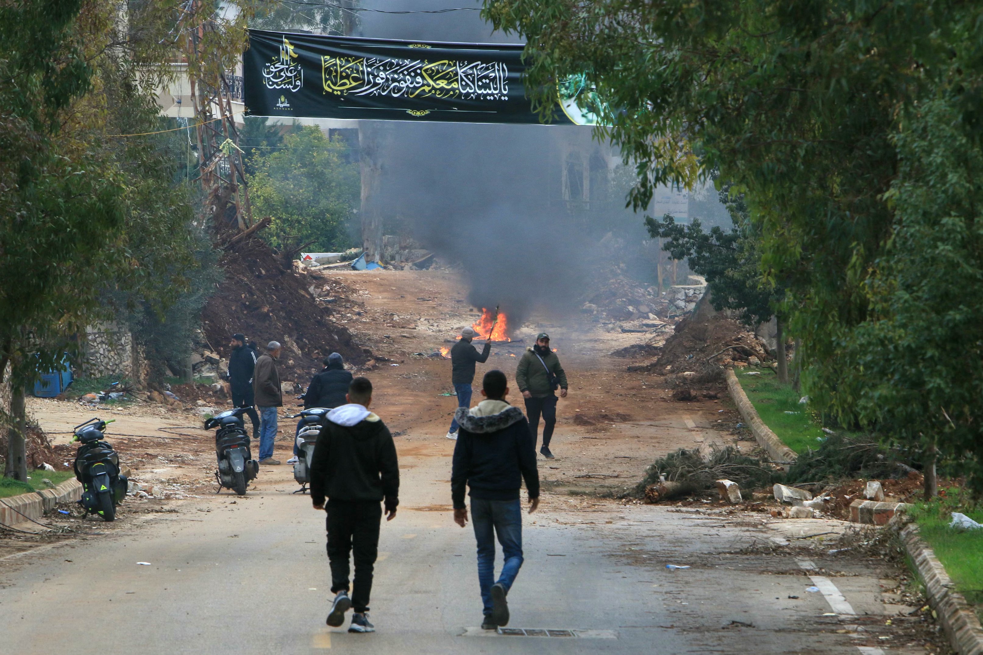 Displaced residents attemting to return to their homes set a fire on a an earth berm placed by Israeli forces to block the entrance to the southern Lebanese village of Aitaroun on January 26, 2025, on the day Israel was meant to withdraw under a truce deal. Israeli army fire killed 15 people in south Lebanon including a soldier on January 26, health officials said, as residents tried to return home on the day Israel was meant to withdraw as part of a ceasefire agreement that ended Israel's war