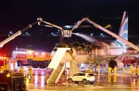 Firefighters work to extinguish a fire that broke out on an Air Busan passenger plane bound for Hong Kong, at Gimhae International Airport in Busan on January 28, 2025. The tail of a passenger aircraft caught fire at an international airport in South Korea’s second-largest city on January 28, forcing the evacuation of 176 people on board, Yonhap news agency reported.