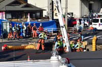 Firefighters work to rescue a truck driver after his vehicle was swallowed up by a sinkhole at a prefectural road intersection, in the city of Yashio, Saitama Prefecture on Jan 28, 2025.