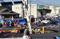 Firefighters work to rescue a truck driver after his vehicle was swallowed up by a sinkhole at a prefectural road intersection, in the city of Yashio, Saitama Prefecture on 28 January 2025.