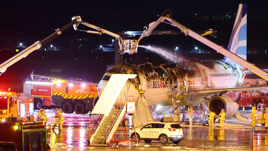 Firefighters work to extinguish a fire that broke out on an Air Busan passenger plane bound for Hong Kong, at Gimhae International Airport in Busan on 28 January 2025. The tail of a passenger aircraft caught fire at an international airport in South Korea's second-largest city on 28 January, forcing the evacuation of 176 people on board, Yonhap news agency reported.