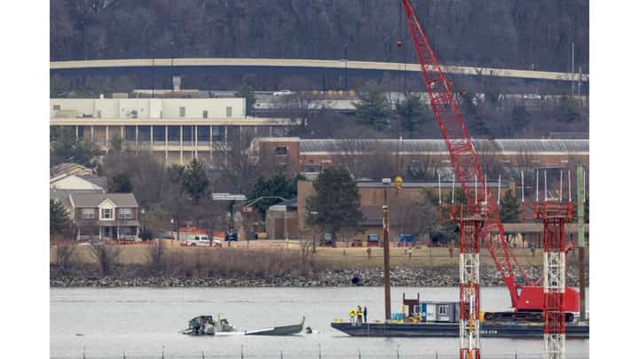 A crane moves in to place on the Potomac River for recovery efforts on 02 February 2025 in Arlington, Virginia. An American Airlines flight from Wichita, Kansas collided midair with a military Black Hawk helicopter while on approach to Ronald Reagan Washington National Airport on 29 January 2025 outside of Washington, DC. According to reports, there were no survivors among the 67 people onboard both aircraft.
