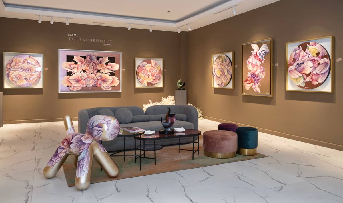 white flower bushes and tall floral-like installations scattered around the gallery.