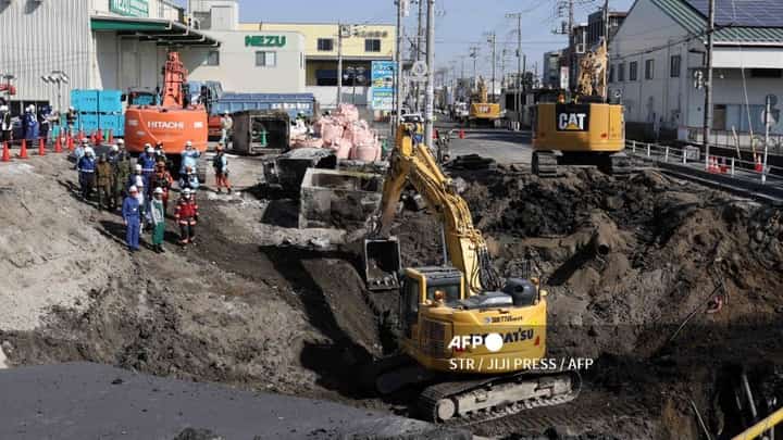LOOK: Excavators and rescue personnel working to construct a slope for rescue operations are seen at the site where a truck on January 28 plunged into a sinkhole, trapping the vehicle's driver, in Yashio, Saitama Prefecture on February 1, 2025. Japanese rescuers completed building a slope on February 1 to reach a truck driver stuck in a sinkhole, officials said, four days after his vehicle was swallowed by the cavity now 40 meters wide.