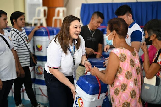 PCSO Director Jennifer Liongson-Guevara distributing aid in Bulacan