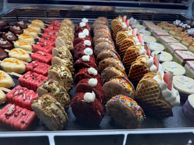 An exquisite Italian gelato counter showcases over 30 handcrafted gelato flavors.