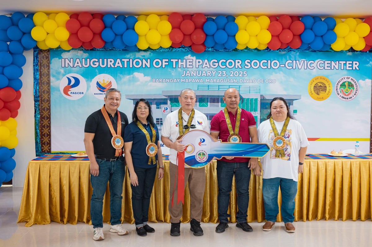 Ramon Stephen Villaflor, PAGCOR’s VP for Corporate Social Responsibility Group (third from left) hands the symbolic key of the newly built socio-civic center to Maragusan Mayor Angelito Cabalquinto (second from right).