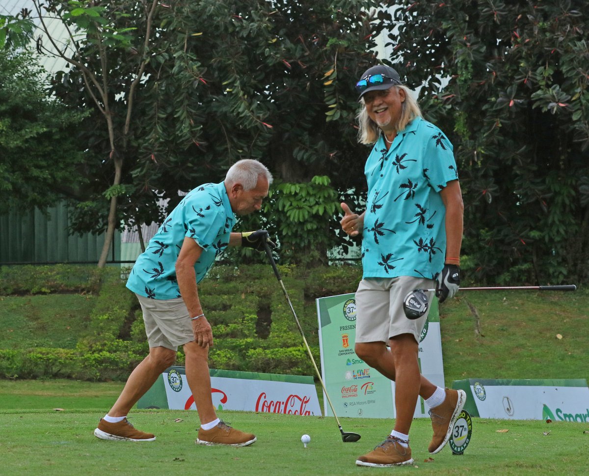 Gualberto Lastrilla smiles as partner Diosdado Zapanta prepares to tee off on the first hole.
