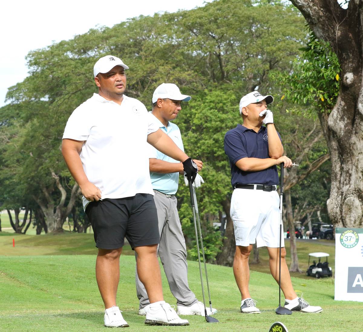 Dax Ramon Garcia, Raymund Sangil and Victor Vergel De Dios wait for their turn on the 11th hole.