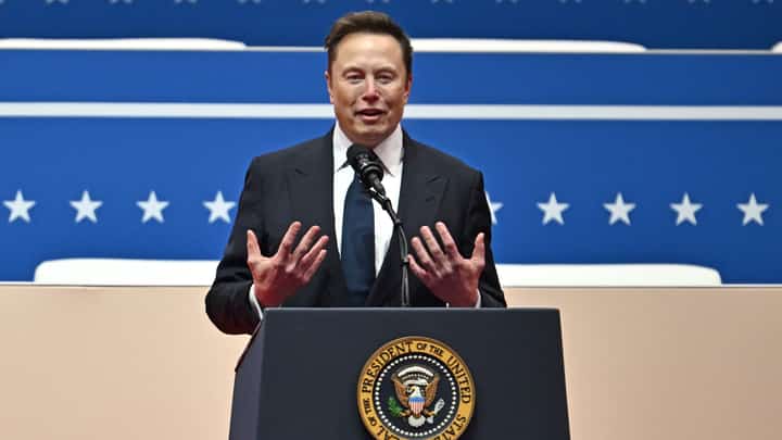 Tesla and SpaceX CEO Elon Musk gestures as he speaks during the inaugural parade inside Capital One Arena in Washington, DC.