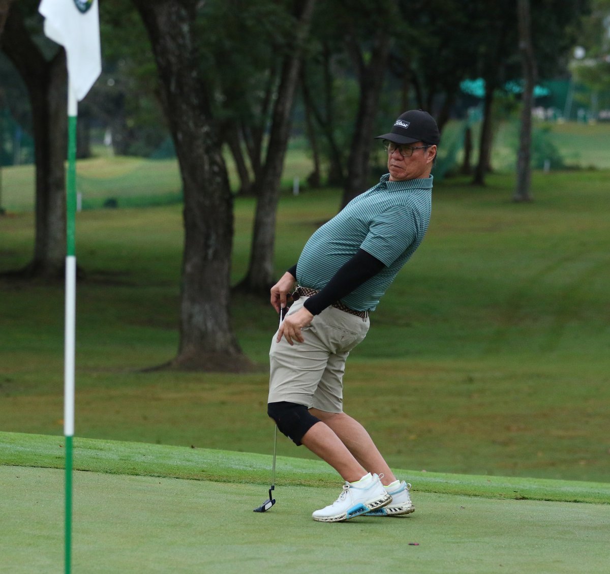Joemarie Limjap uses some body English after making his putt on the first green.
