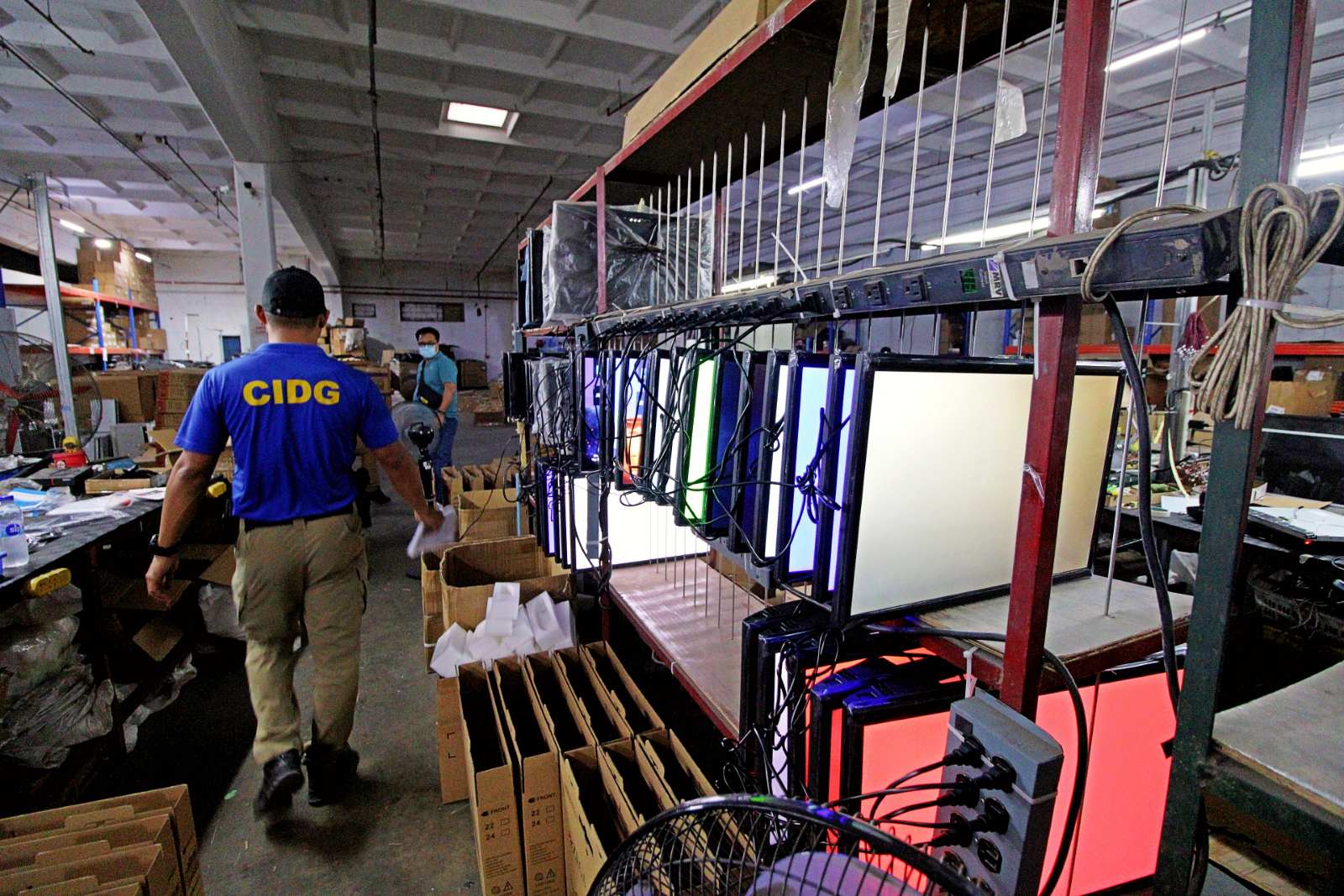 CIDG Police Capt. Jan Michael Jardin shows off the monitors that were being made into counterfeit TVs at an electronics store at the Corregidor Highway, Ilanin West District of the Subic Bay Freeport.
