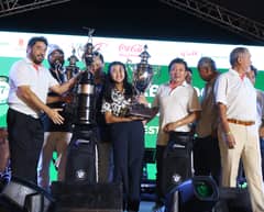 Raymond Abelido, represented by daughter Robyn, and Temie Lambino accept their trophies for securing the overall net title in the 37th Mango Tee Invitational late Saturday at the Alabang Country Club.