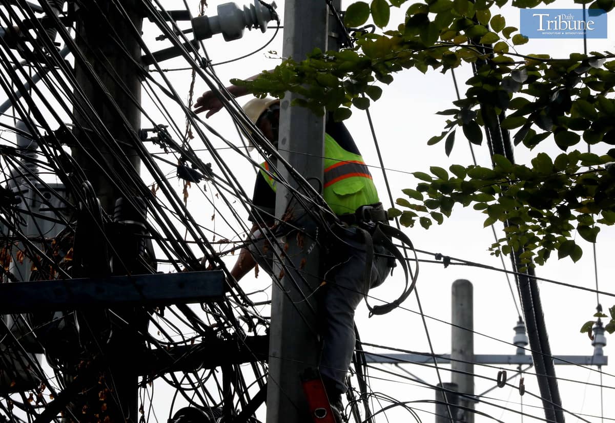A Meralco contractor electrician from Miescor was seen repairing wires atop an electric post along Merriam-Defensor Santiago Avenue on Monday. Meralco announced scheduled power interruptions across several areas in Metro Manila and Calabarzon from 10 to 17 February due to maintenance work.
