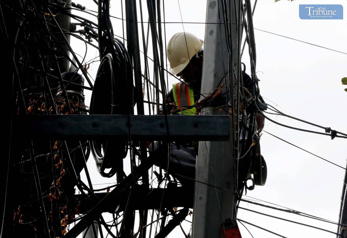 A Meralco contractor electrician from Miescor was seen repairing wires atop an electric post along Merriam-Defensor Santiago Avenue on Monday. Meralco announced scheduled power interruptions across several areas in Metro Manila and Calabarzon from 10 to 17 February due to maintenance work.