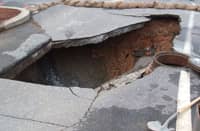 This is a sinkhole in a parking lot at Georgia Tech in Atlanta, GA, USA. A contractor I spoke with said the hole was 32 feet deep. It was formed as rainwater leaked through the pavement and into a break in the sewer line below.