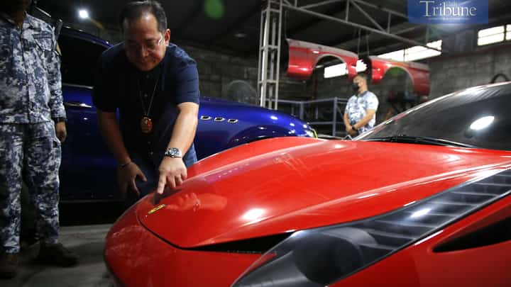 Manila Field Station Chief Alvin Enciso of the CIIS-MICP inspects seized luxury vehicles suspected of being smuggled into the country without payment of duties and taxes on imported goods in Taguig City on 21 February 2025. This marks the third CIIS raid in Metro Manila since last week.