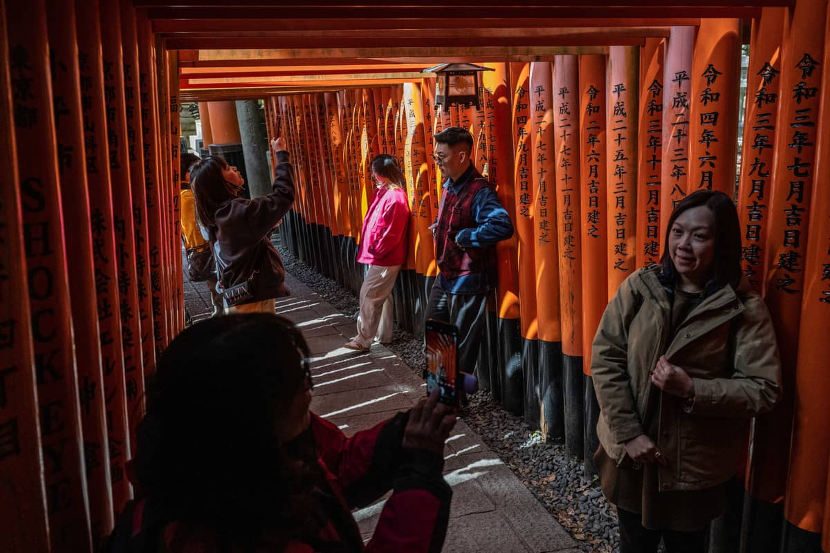 In this picture taken on 10 March 2024, people take pictures at the Torii path of Fushimi Inari-taisha shrine in Kyoto.
