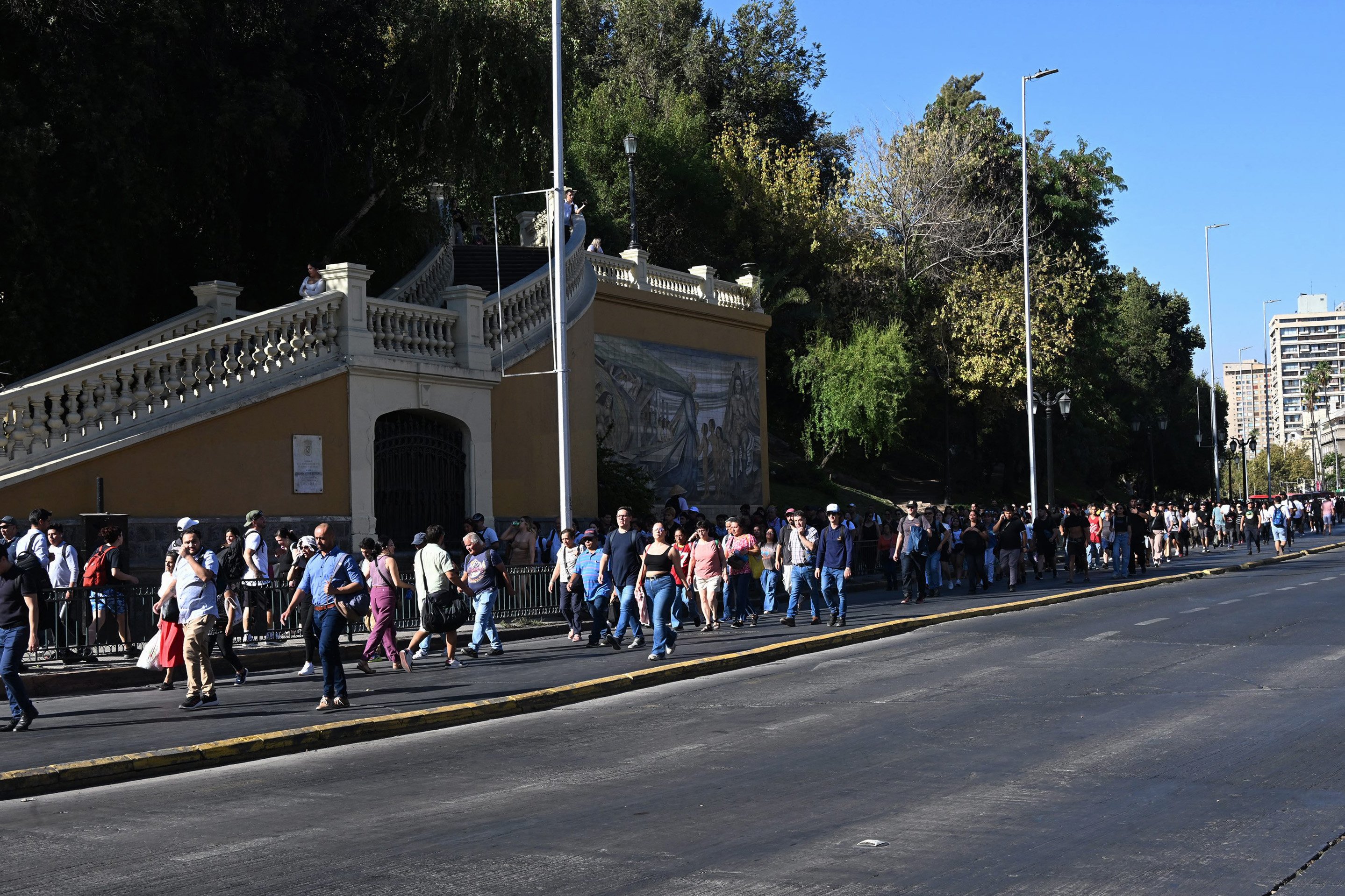 People walk in the middle of Alameda Avenue during a blackout in Santiago on 25 February 2025. In the middle of the austral summer season, Chile is facing this Tuesday an unusual and massive blackout due to an alleged failure of the power system, which forced the evacuation of the Santiago subway and plunged the population into confusion.
